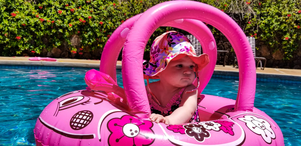 baby in pink float toy in pool