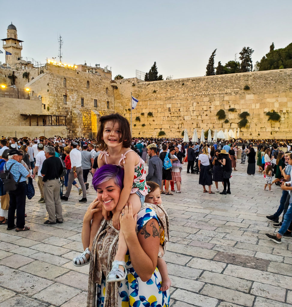 woman holding baby and toddler in front of western wall jerusalem israel