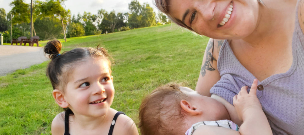 woman breastfeeding in park in tel aviv with toddler
