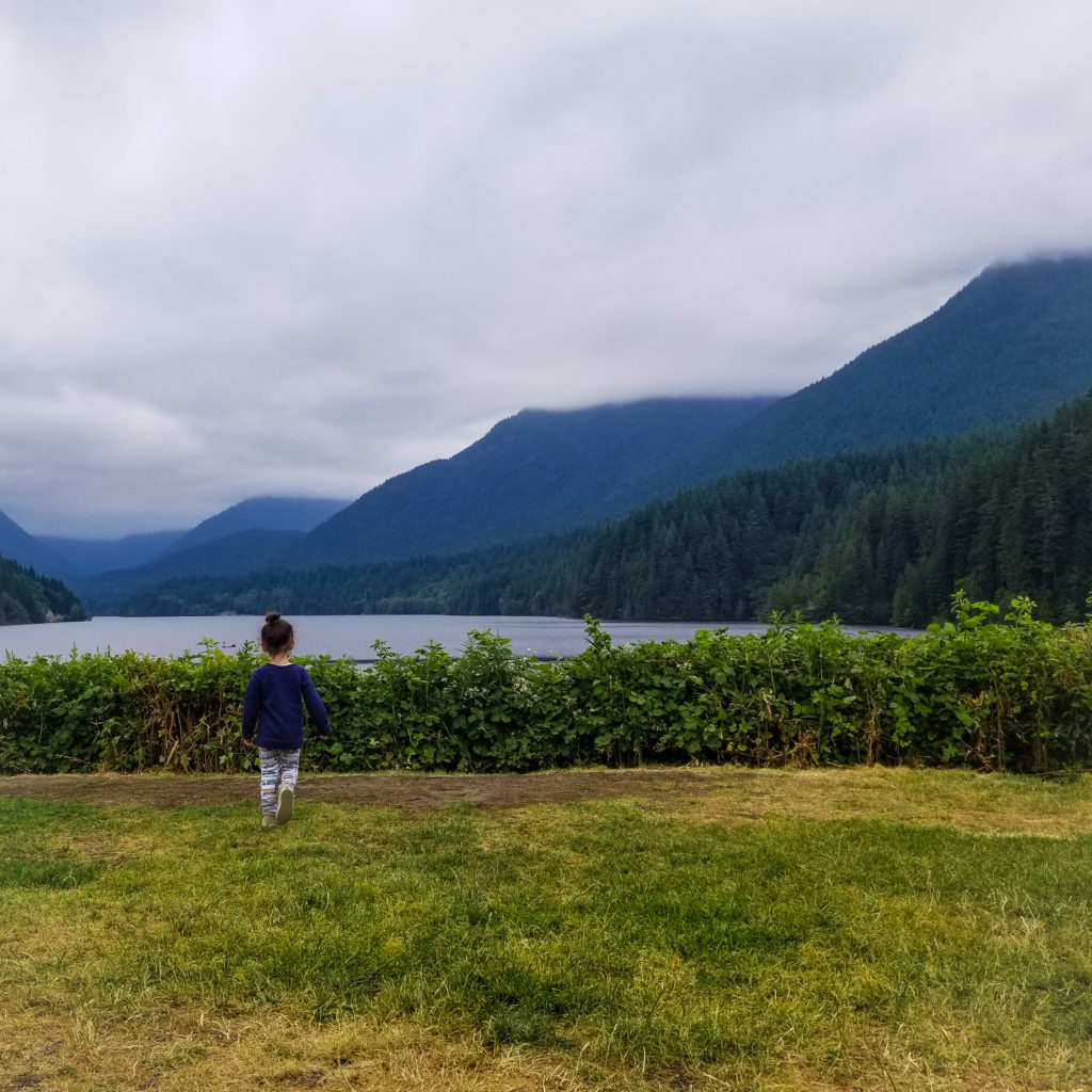 toddler in vancouver staring out over lake and mountains