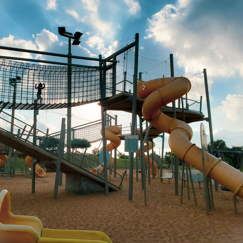 toddler climbing toward tall slides in herzliya park