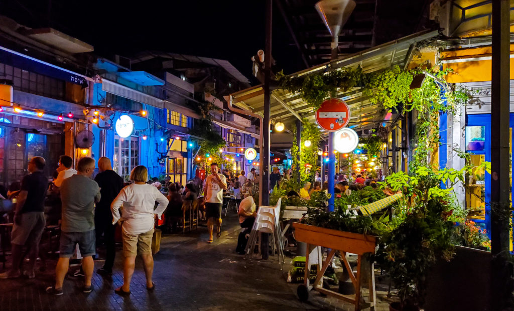 brightly lit alleyway full of people at night