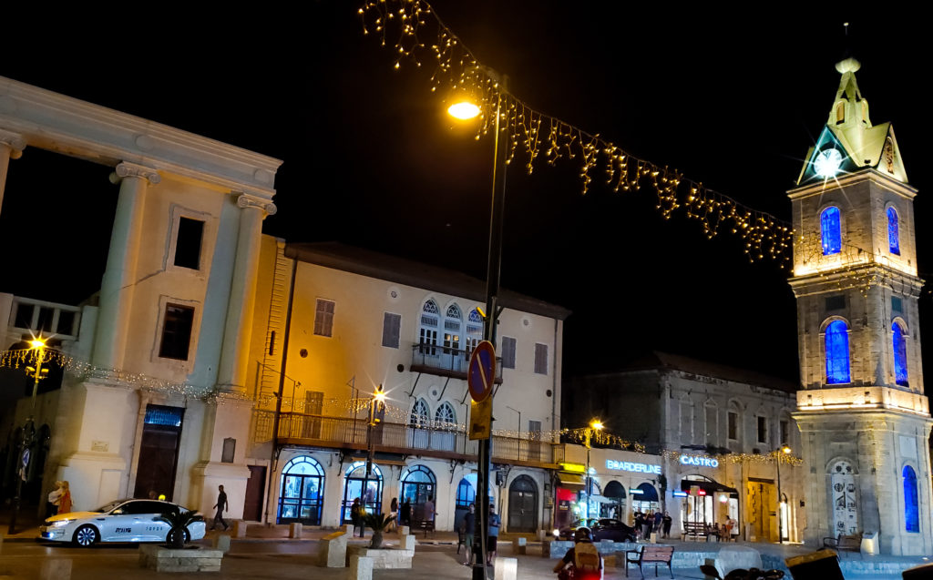 lit up clock tower overlooking street at night