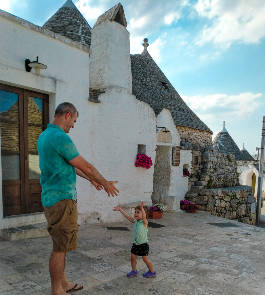 father with toddler in alberobello, running to hug
