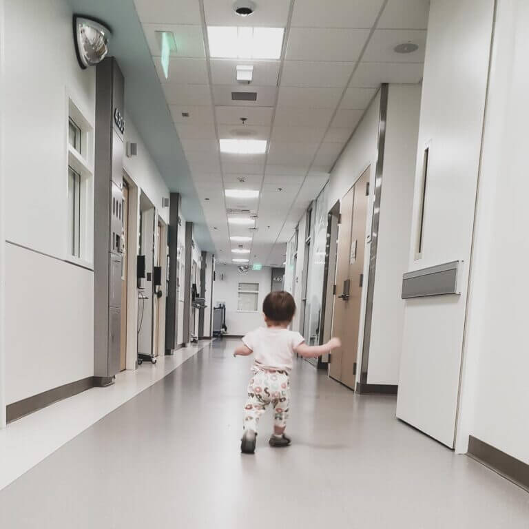 Toddler walking through hospital hallway
