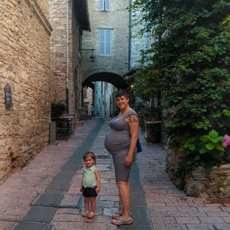 pregnant woman and toddler standing in Italian road