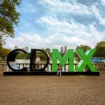 large CDMX sign with lake and skyline in backgroudn and toddler and child on the letters