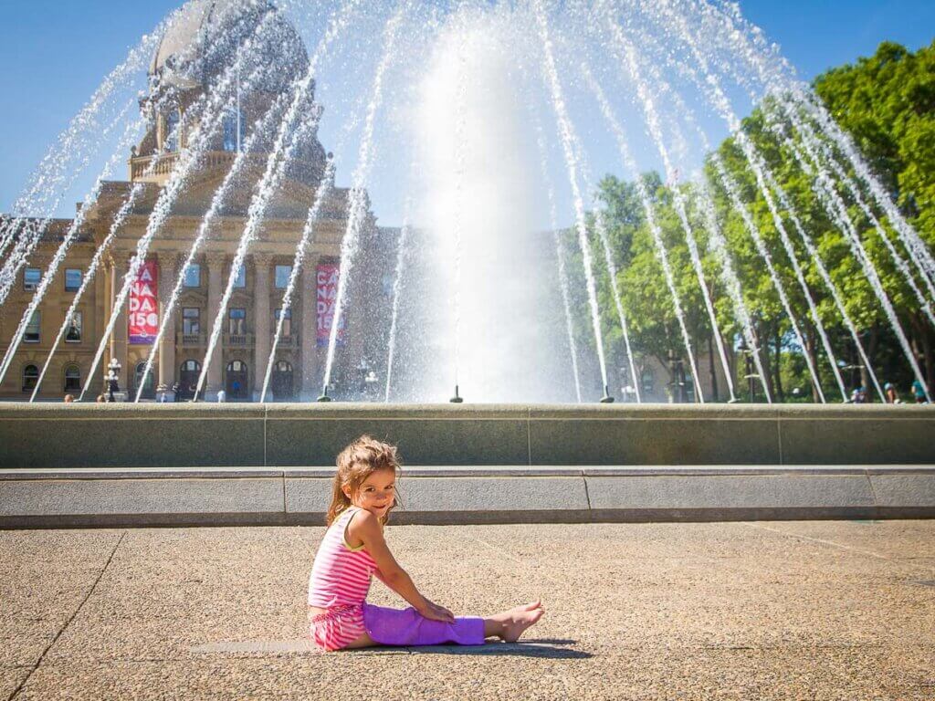 toddler girl in front of fountain with legislature building in background