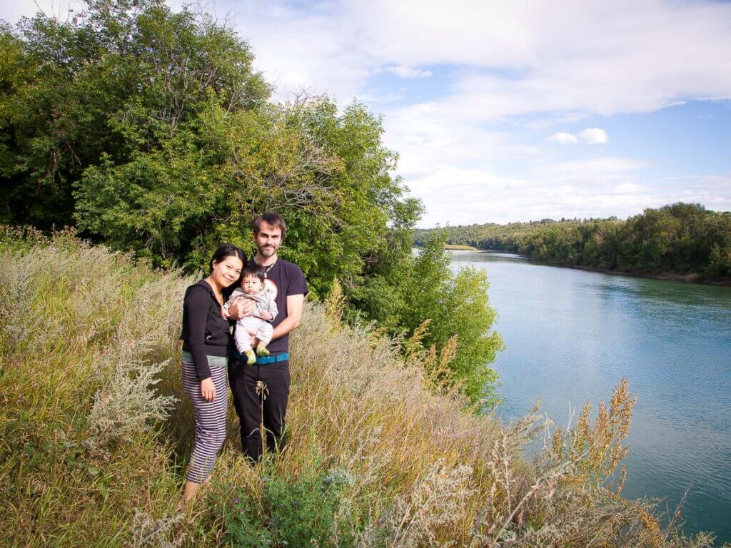 couple with baby on shore overlooking river