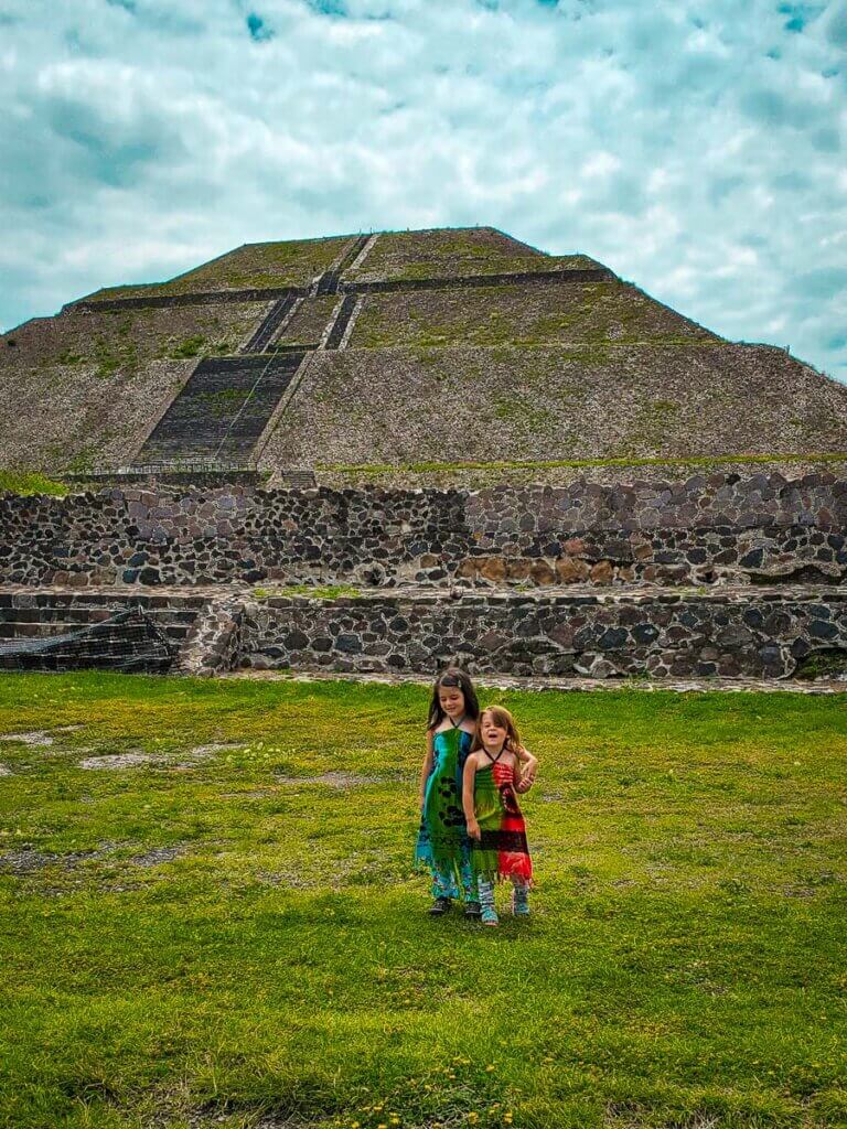 two young sisters in front of tall pyramid