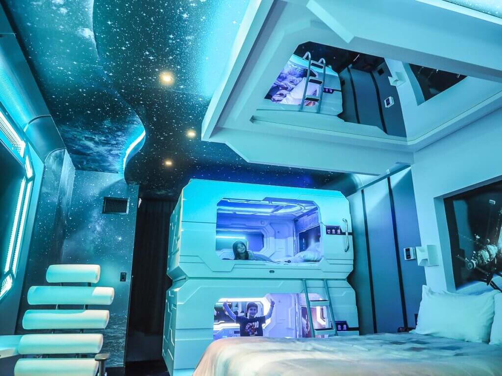 very futuristic room with kids in space-themed bunk beds