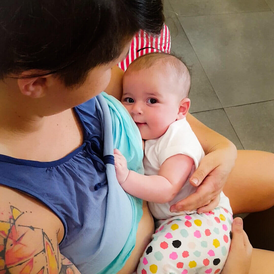baby smiling while breastfeeding while traveling in thailand